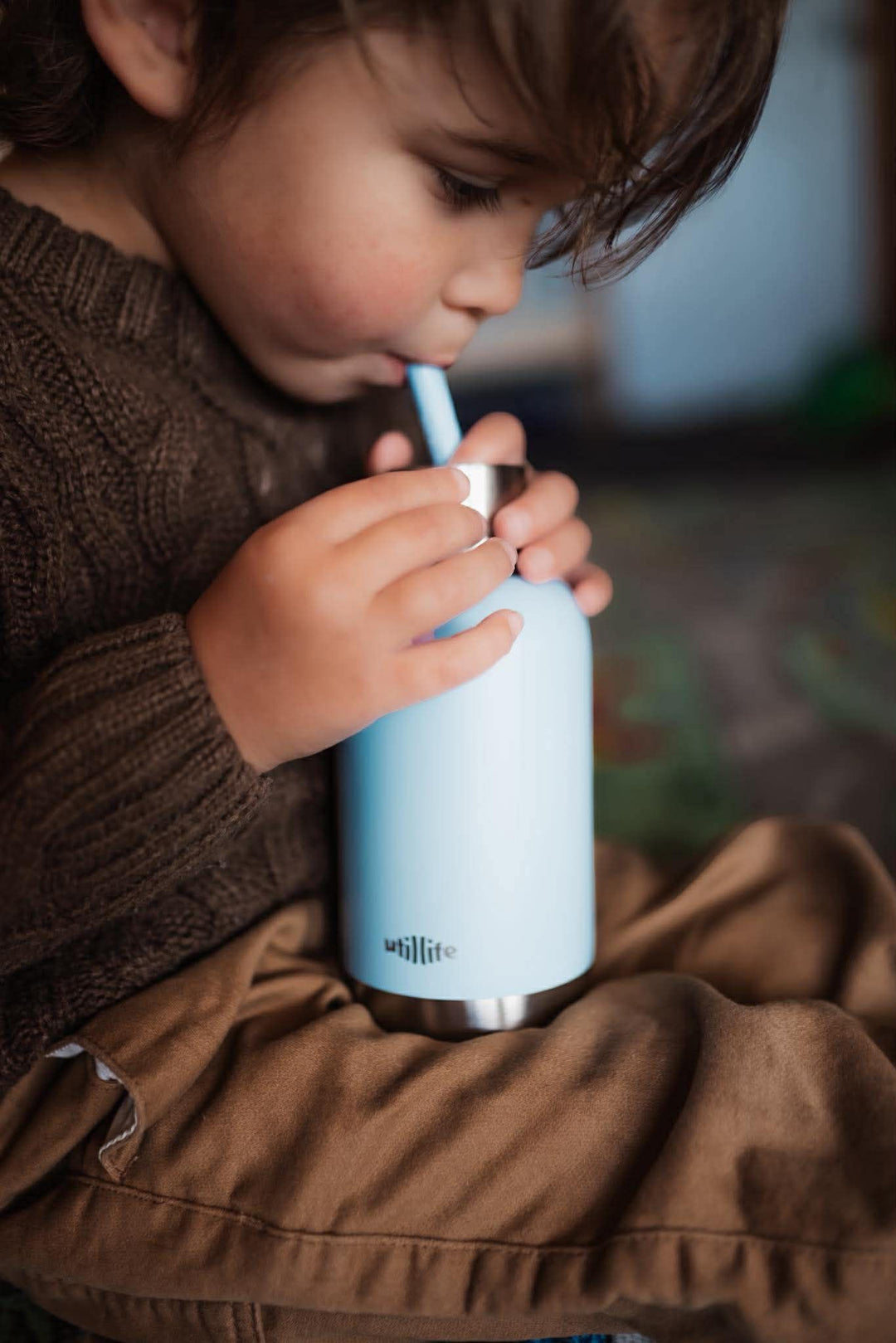 A kid drinking from his koala milo pijo bottle