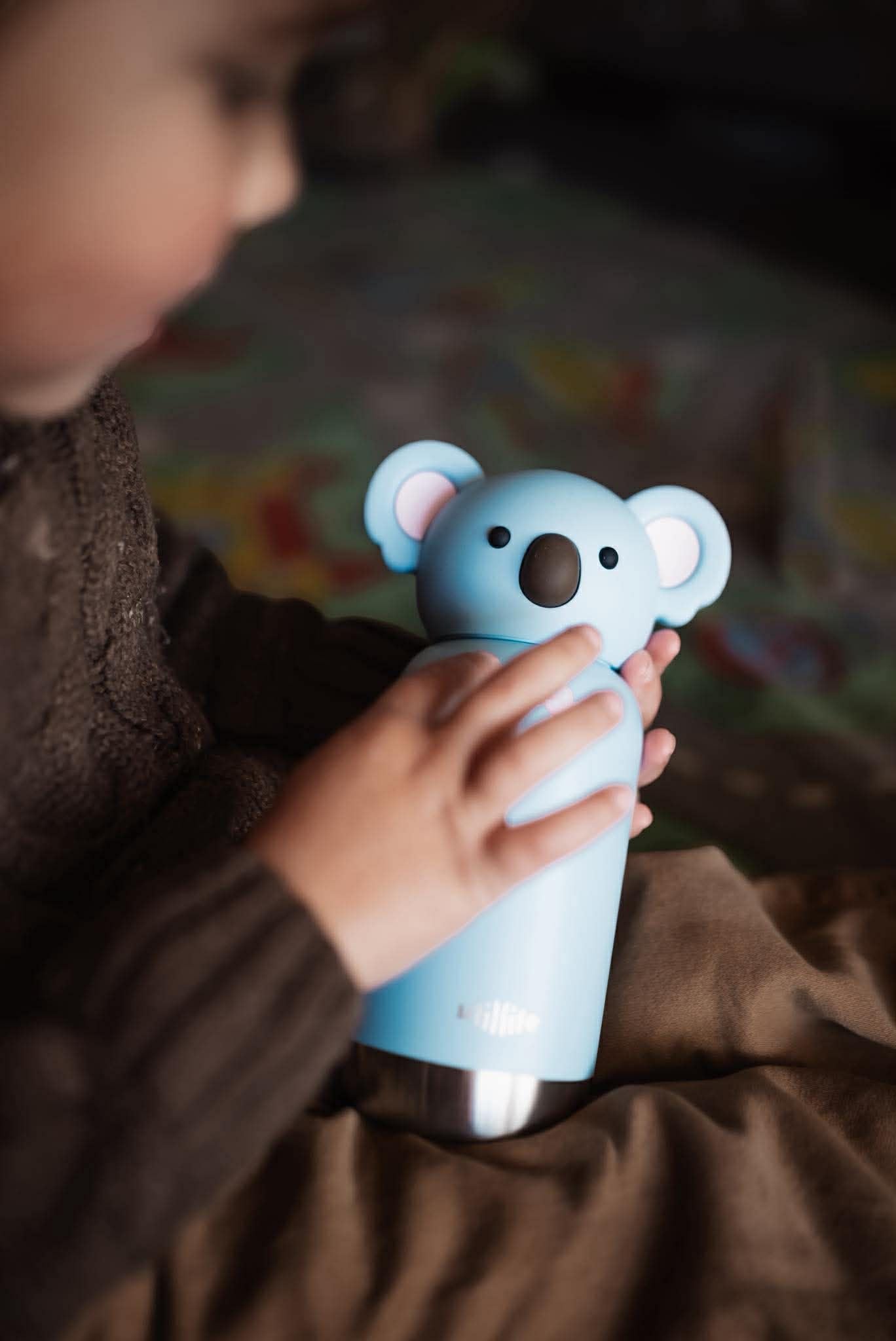 A kid holding his koala milo pijo bottle